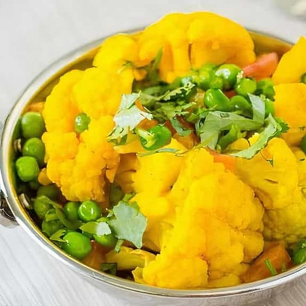 Chaat House's Gobi Matar, a vibrant Indian dish with yellow cauliflower, green peas, and cilantro.