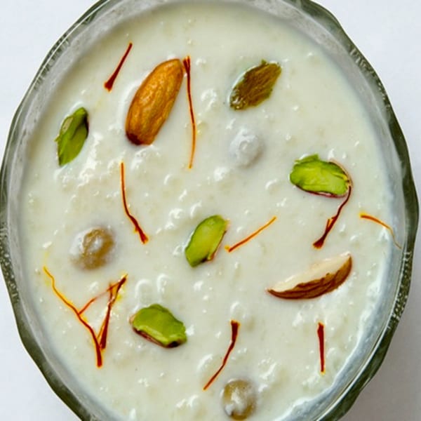 Close-up of Indian rice pudding (kheer) topped with almonds, pistachios, and saffron threads.